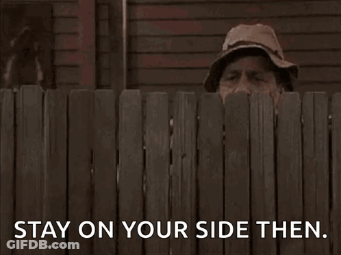 A Man Peeking Over A Wooden Fence With The Words Stay On Your Side Then . GIF