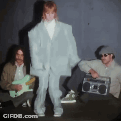 A Man Playing A Guitar And A Man Holding A Boom Box GIF