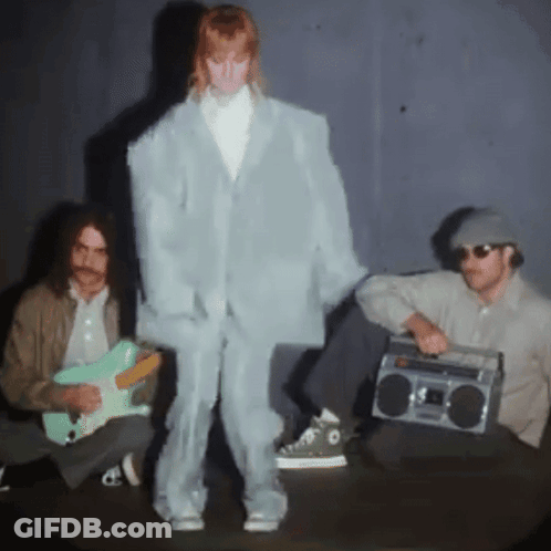 A Man Playing A Guitar And A Man Holding A Boom Box GIF