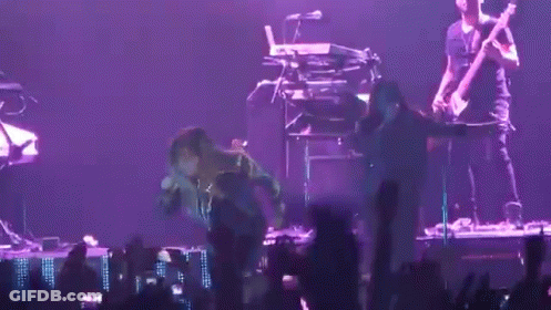 A Man Playing A Guitar And Another Man Playing A Keyboard Are On A Stage GIF