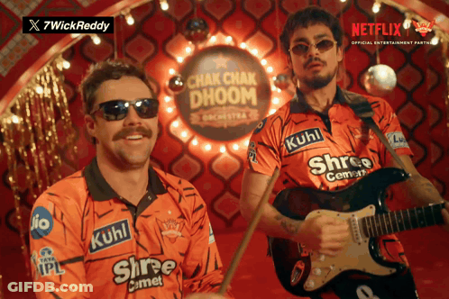 A Man Playing A Guitar And Another Man Playing Drums In Front Of A Sign That Says Chak Chak Dhoom GIF