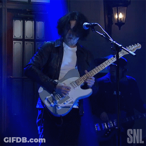 A Man Playing A Guitar And Singing Into A Microphone With Snl Written On The Bottom GIF