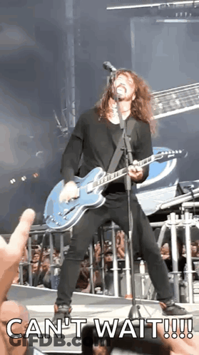 A Man Playing A Guitar And Singing Into A Microphone With The Words Can 'T Wait GIF