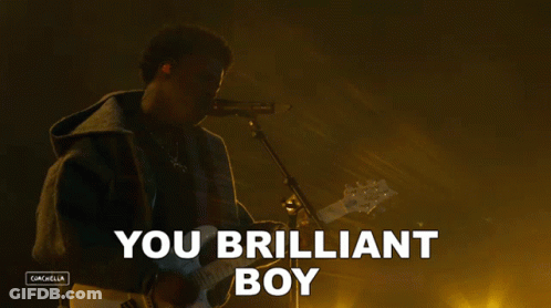 A Man Playing A Guitar And Singing Into A Microphone With The Words You Brilliant Boy Above Him GIF