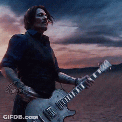 A Man Playing A Guitar In A Desert With A Twitter Logo On The Bottom Right GIF