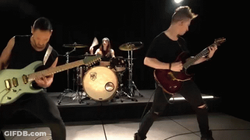 A Man Playing A Guitar In Front Of A Drum Set With A Sticker That Says ' Sr ' On It GIF