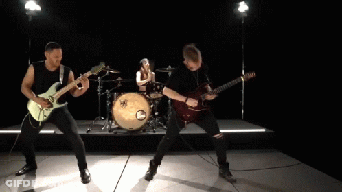 A Man Playing A Guitar In Front Of A Drum Set With A Yamaha Logo On It GIF