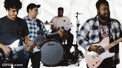 A Man Playing A Guitar In Front Of A Ludwig Drum Set GIF