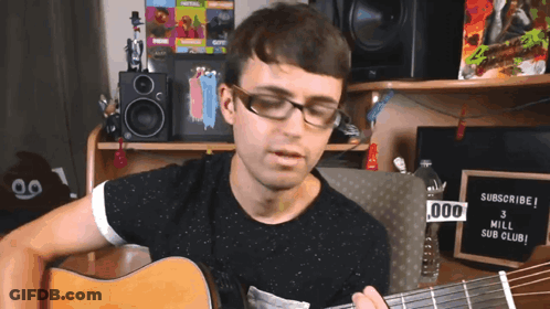 A Man Playing A Guitar In Front Of A Sign That Says " Subscribe " GIF