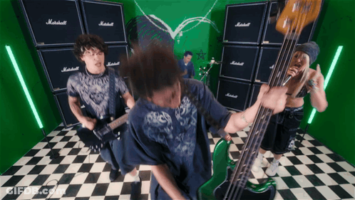 A Man Playing A Guitar In Front Of A Wall Of Marshall Amplifier Stacks GIF