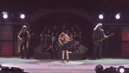 A Man Playing A Guitar In Front Of A Wall Of Marshall Amplifiers GIF