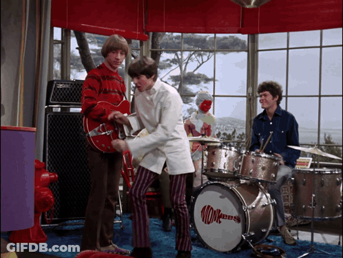 A Man Playing A Guitar Next To A Monkey Dbs Drum GIF