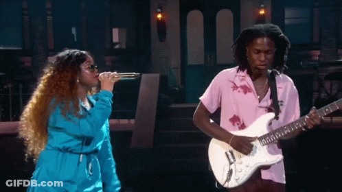 A Man Playing A Guitar Next To A Woman Singing GIF
