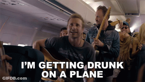 A Man Playing A Guitar On A Plane With The Words " I 'M Getting Drunk On A Plane " GIF