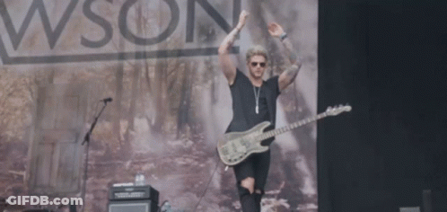 A Man Playing A Guitar On A Stage In Front Of A Sign That Says Wson GIF
