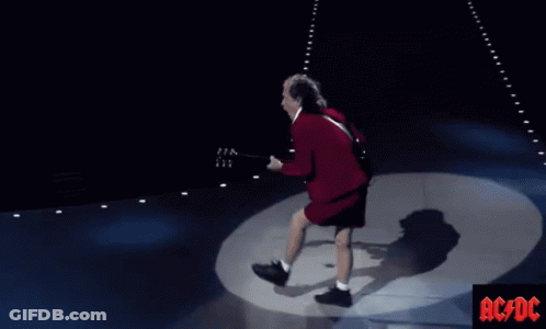 A Man Playing A Guitar On A Stage With Ac/dc Written On The Bottom Right GIF