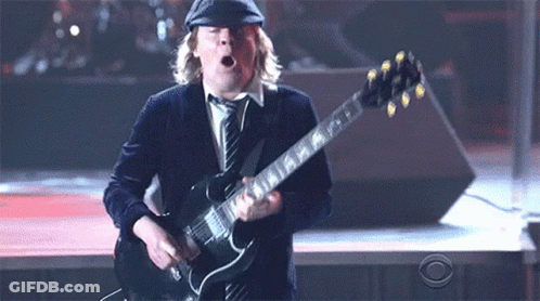A Man Playing A Guitar With A Cbs Logo Behind Him GIF