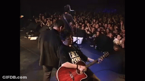 A Man Playing A Guitar With A Shirt That Says ' Fuck Prison ' On It GIF