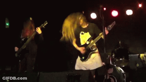 A Man Playing A Guitar With The Letter C On The Front GIF