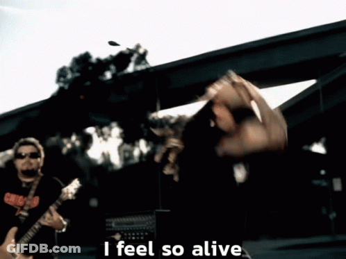 A Man Playing A Guitar With The Words " I Feel So Alive " Below Him GIF