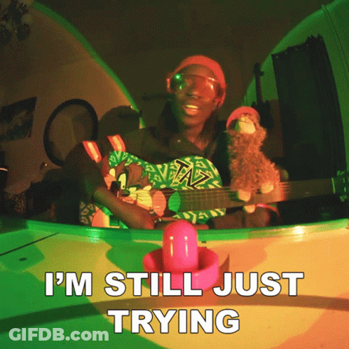 A Man Playing A Guitar With The Words I 'M Still Just Trying On The Bottom GIF