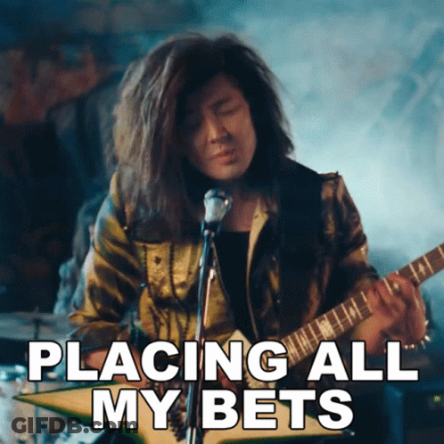 A Man Playing A Guitar With The Words Placing All My Bets Written Below Him GIF