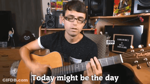 A Man Playing A Guitar With The Words " Today Might Be The Day " Behind Him GIF