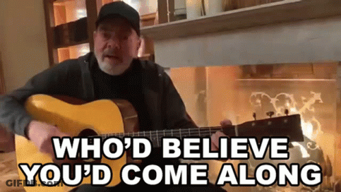 A Man Playing A Guitar With The Words " Who 'D Believe You 'D Come Along " Below Him GIF