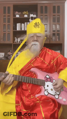 A Man Playing A Pink Hello Kitty Guitar GIF