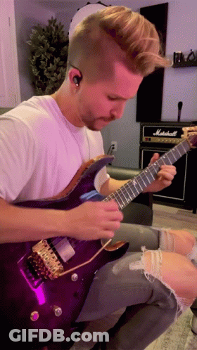 A Man Playing A Purple Guitar In Front Of A Marshall Amplifier GIF