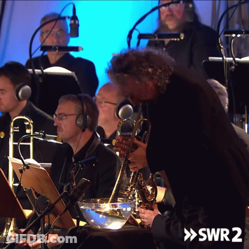 A Man Playing A Saxophone In An Orchestra With The Words Swr2 On The Bottom Right GIF