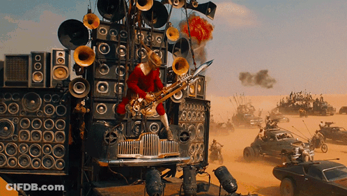 A Man Playing A Saxophone On Top Of A Car With A Lot Of Speakers On It GIF