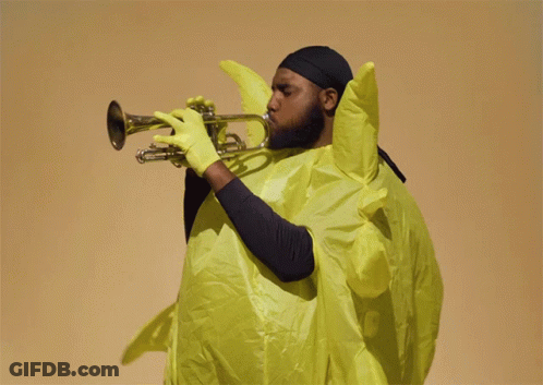 A Man Playing A Trumpet In A Yellow Outfit GIF