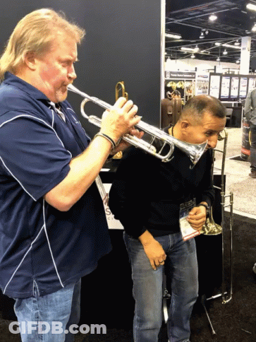 A Man Playing A Trumpet Next To Another Man GIF