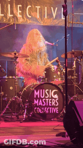 A Man Playing Drums In Front Of A Drum Set That Says Music Masters Collective GIF