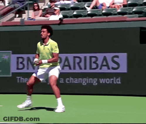 A Man Playing Tennis In Front Of A Bn Paribas Ad GIF