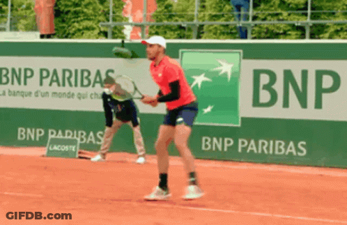A Man Playing Tennis In Front Of A Bnp Banner GIF