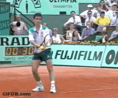 A Man Playing Tennis In Front Of A Fujifilm Banner GIF