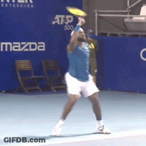 A Man Playing Tennis In Front Of A Mazda Ad GIF
