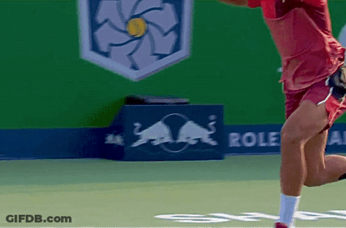 A Man Playing Tennis In Front Of A Red Bull Sign GIF