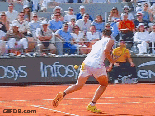 A Man Playing Tennis On A Court With A Sign That Says Infosys GIF
