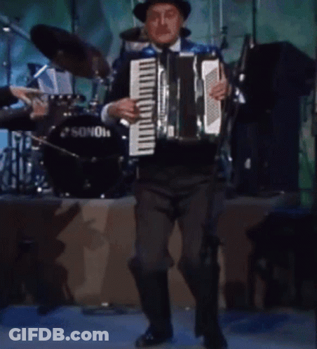 A Man Plays An Accordion In Front Of A Sonor Drum GIF