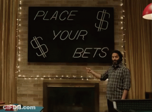 A Man Pointing At A Sign That Says Place Your Bets GIF