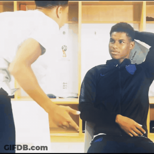 A Man Pointing At Another Man In A Locker Room That Says ' England ' On The Wall GIF
