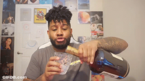 A Man Pouring A Drink From A Bottle With A Label That Says ' Glenlivet ' GIF