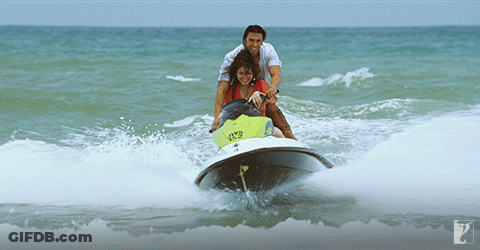 A Man Pushes A Woman On A Jet Ski In The Ocean GIF