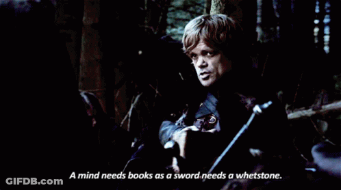A Man Reading A Book With The Words " A Mind Needs Books As A Sword Needs A Whetstone " Next To Him GIF