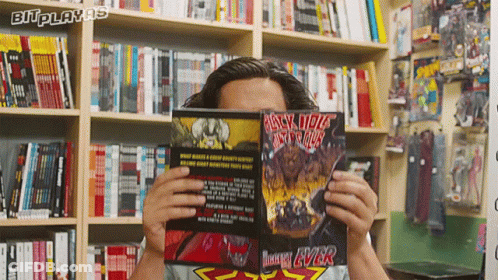 A Man Reads A Comic Book Called Black Hole GIF