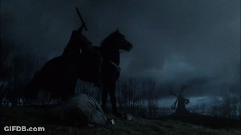 A Man Riding A Black Horse In A Field GIF