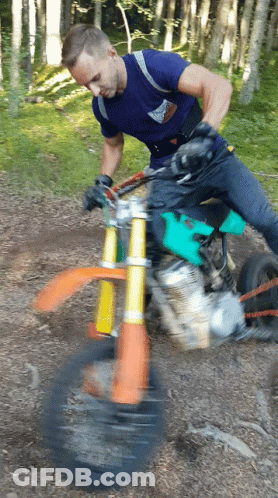 A Man Riding A Dirt Bike In The Woods GIF